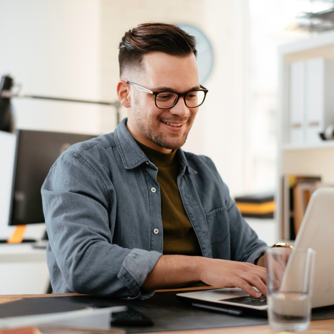 Marketing student in glasses in an online Master of Science in Marketing class on laptop.