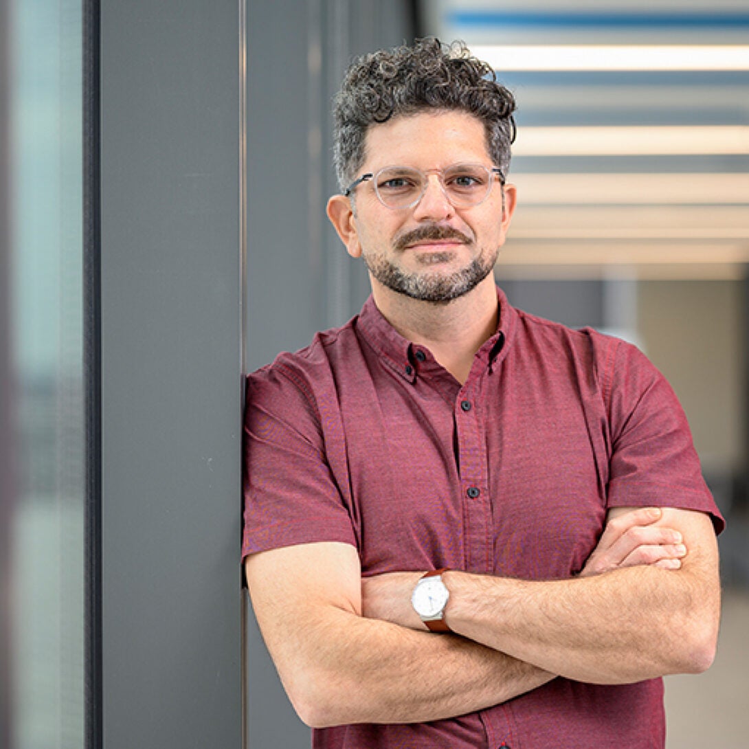 MS in Marketing Dr. Manuel Hermosilla, smiles at camera next to window